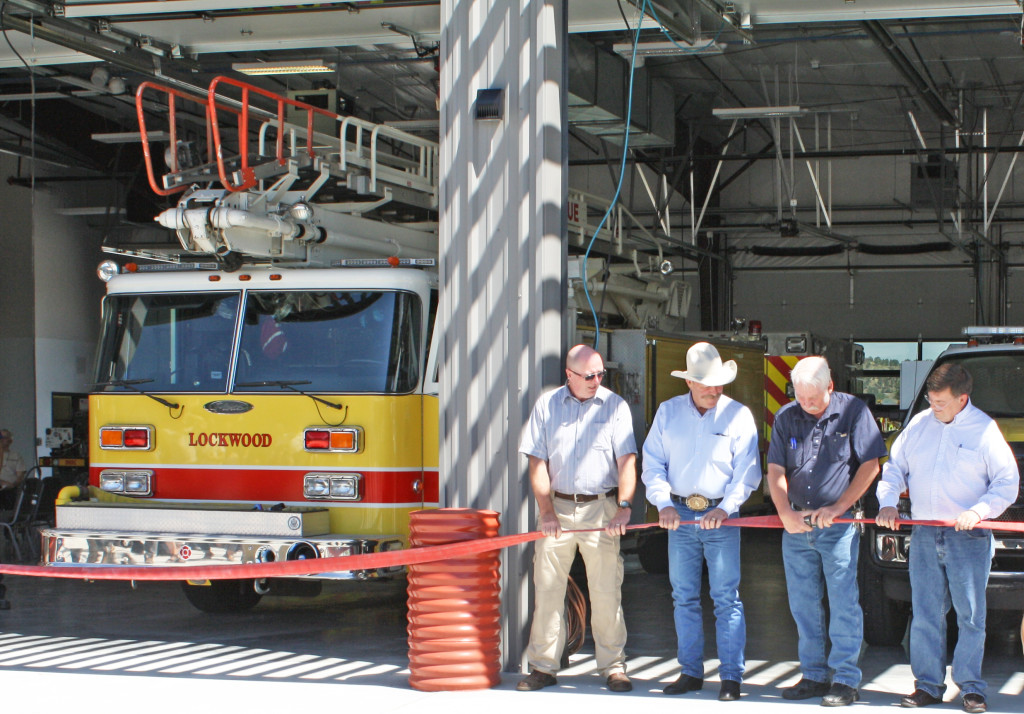 The Lockwood Fire Department took an alternative route to ribbon-cutting on Friday, July 31 when its new fire station was dedicated. Instead of cutting a ribbon, fire district board members and Yellowstone County commissioners uncoupled a fire hose. Shown from left are board member Cliff Mahoney, commissioner John Ostlund, Lockwood fire board chairman Xzlmer Anderson and commissioner Bill Kennedy. (Gayle Staley photo)