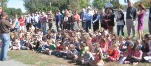 Dozens of Lockwood students listen on Wednesday to Nic Talmark, chairman of the Lockwood Pedestrian Safety Board. The students were honored guests at a ground-breaking ceremony attended by Talmark and other officials, including Yellowstone County commissioners, for a new sidewalk along Highway 87 East. (Evelyn Pyburn photo) 