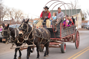 Happy Pappy, front left, of Western Romance Company giving free mule-drawn wagon rides to Keith Rauch, front right, of Shepherd, and his family last year at the Huntley Christmas Stroll. Free wagon rides will be available in Huntley from noon – 4 p.m. Saturday, Dec. 19, weather permitting. (Jonathan McNiven Photo)